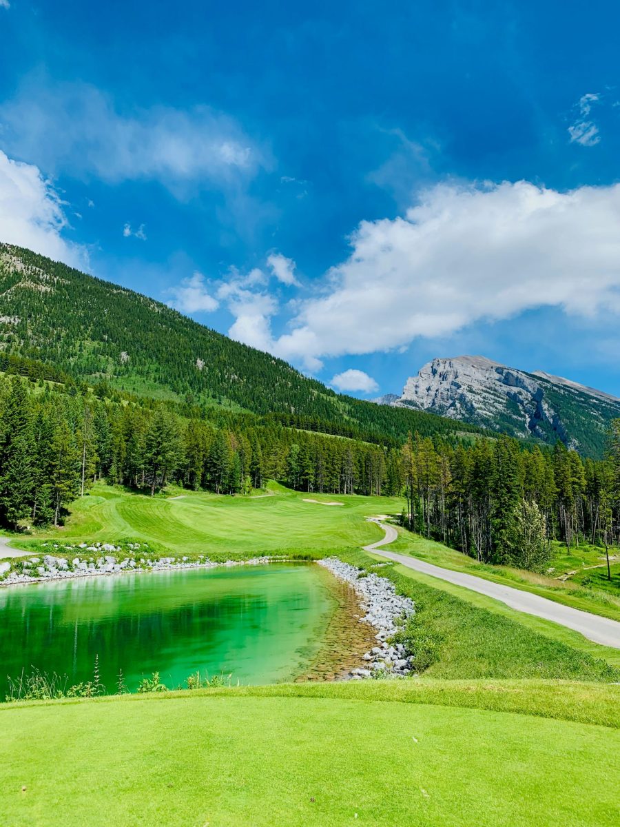 Golfer auf einem alpinen Golfplatz mit Bergkulisse und klarem Himmel