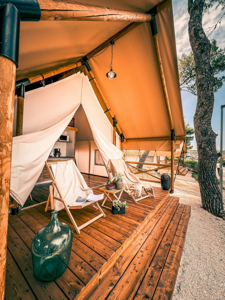 Luxus-Glamping-Zelt mit Holzterrasse und stilvoller Einrichtung in der Natur