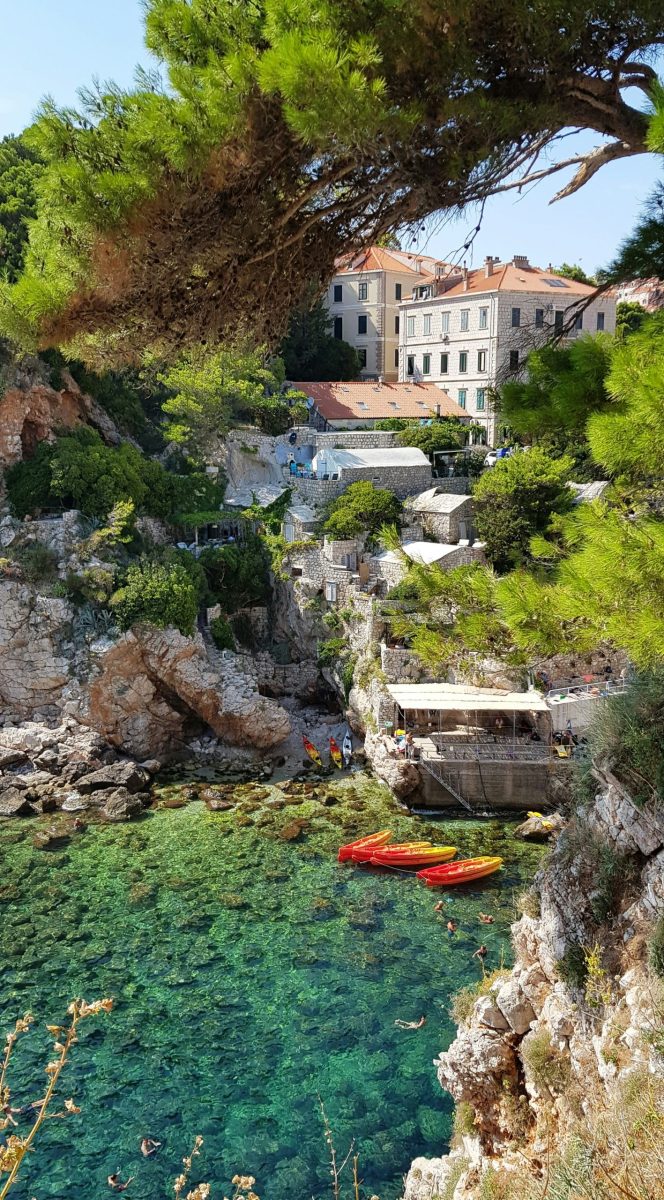 Kinder spielen am Kiesstrand mit klarem Wasser in Kroatien