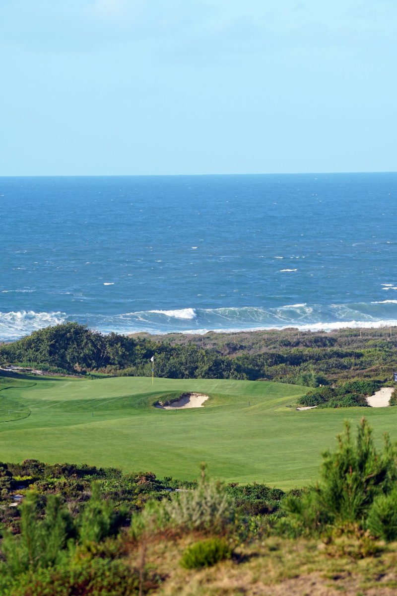 Golfer schlägt auf einem Küstengolfplatz mit Blick auf das Meer ab