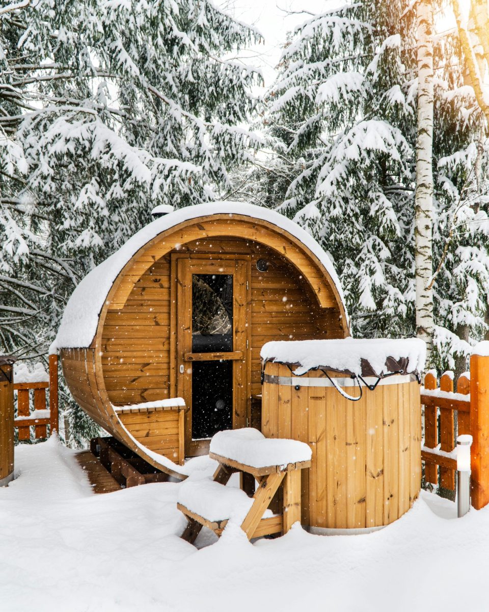 Frau entspannt in einer Berghütte mit Sauna und Panoramablick auf die Alpen