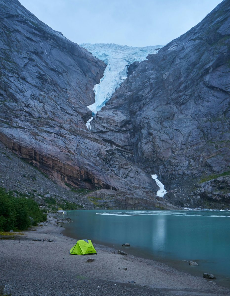 Campervan auf einem Fjord-Campingplatz mit Bergen und Nordlichtern